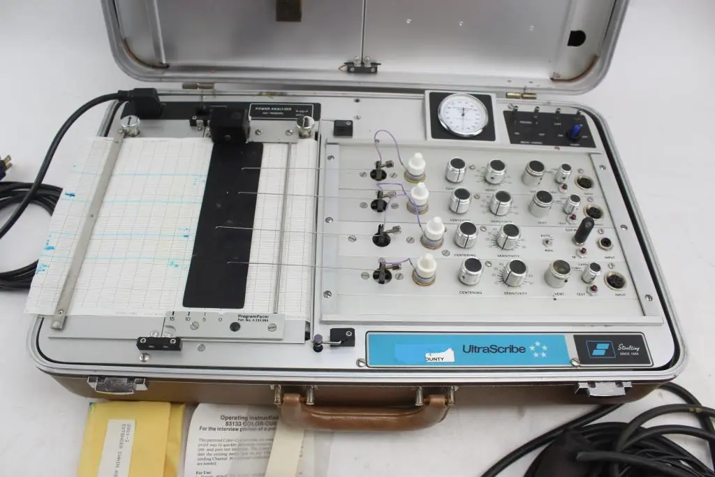Stoelting UltraScribe analogue polygraph open in its aluminium case — pen array, chart paper, centering and sensitivity controls